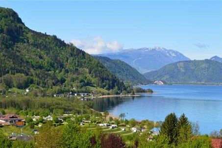 Sicht über unsere grünen Terrassen und den blauen Ossiacher See zur Villacher Alpe unter strahlendem Himmel!