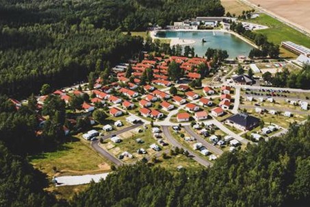 Trixi Ferienpark mit Campingplatz – Panoramabild mit Blick auf Saunagarten, Waldstrandbad und Feriendorf mit Campingplatz, im Hintergrund das Zittauer Gebirge 